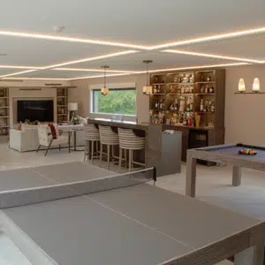 Bespoke steel frame garden room configured into a premium luxury garden bar, featuring an elegant modern beverage lounge, bespoke counter seating, and contemporary architectural glazing for a total garden transformation.