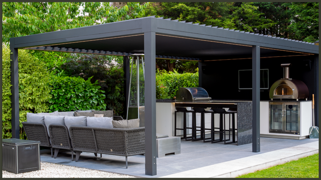 A beautifully styled modern black aluminium pergola shading a high-end outdoor dining and lounge set on a premium stone patio, showcasing an attractive garden feature that boosts property curb appeal.