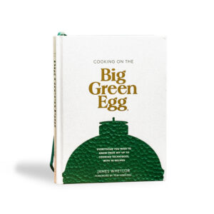 A professional e-commerce product shot of the "Cooking on the Big Green Egg" cookbook, showcasing its vibrant, high-quality cover photography filled with inspiring outdoor grilling recipes.