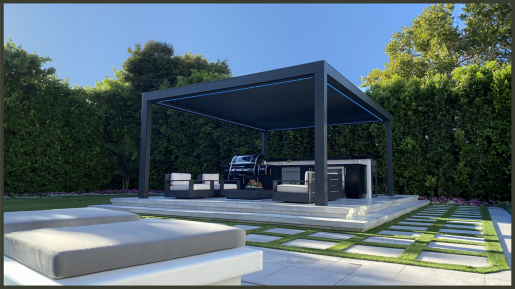 A panoramic view of a beautifully landscaped UK garden layout featuring a modern black aluminium louvred pergola over a patio seating area, demonstrating high-end architectural garden shelter.