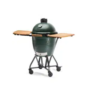 A professional e-commerce product shot of the Big Green Egg Integrated Nest with Acacia Shelves for the Large EGG, showcasing the heavy-duty black steel rolling frame and the two folding, slatted premium acacia wood side tables.