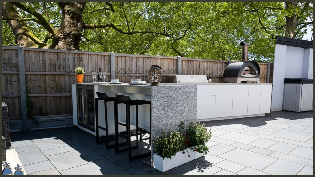 A luxury custom-built outdoor kitchen with premium stainless steel appliances and stone worktops, seamlessly integrated into a contemporary patio area in Greenhill Gardens, Barnet.