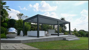 A stunning 2026 luxury backyard featuring a contemporary bioclimatic aluminium pergola with automated rotating louvres, integrated ambient LED strip lighting, and drop-down weatherproof side screens shelter a plush outdoor lounge area.