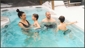 A pristine luxury swim spa using a natural mineral water purification system, showing crystal-clear water in a landscaped garden patio.